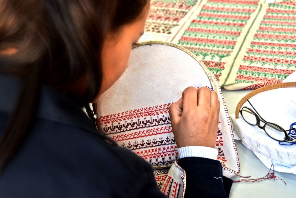 A woman skillfully hand-embroiders intricate patterns in a Fès, Morocco workshop.