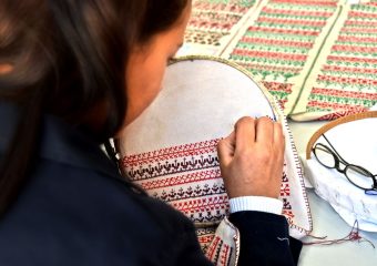 A woman skillfully hand-embroiders intricate patterns in a Fès, Morocco workshop.